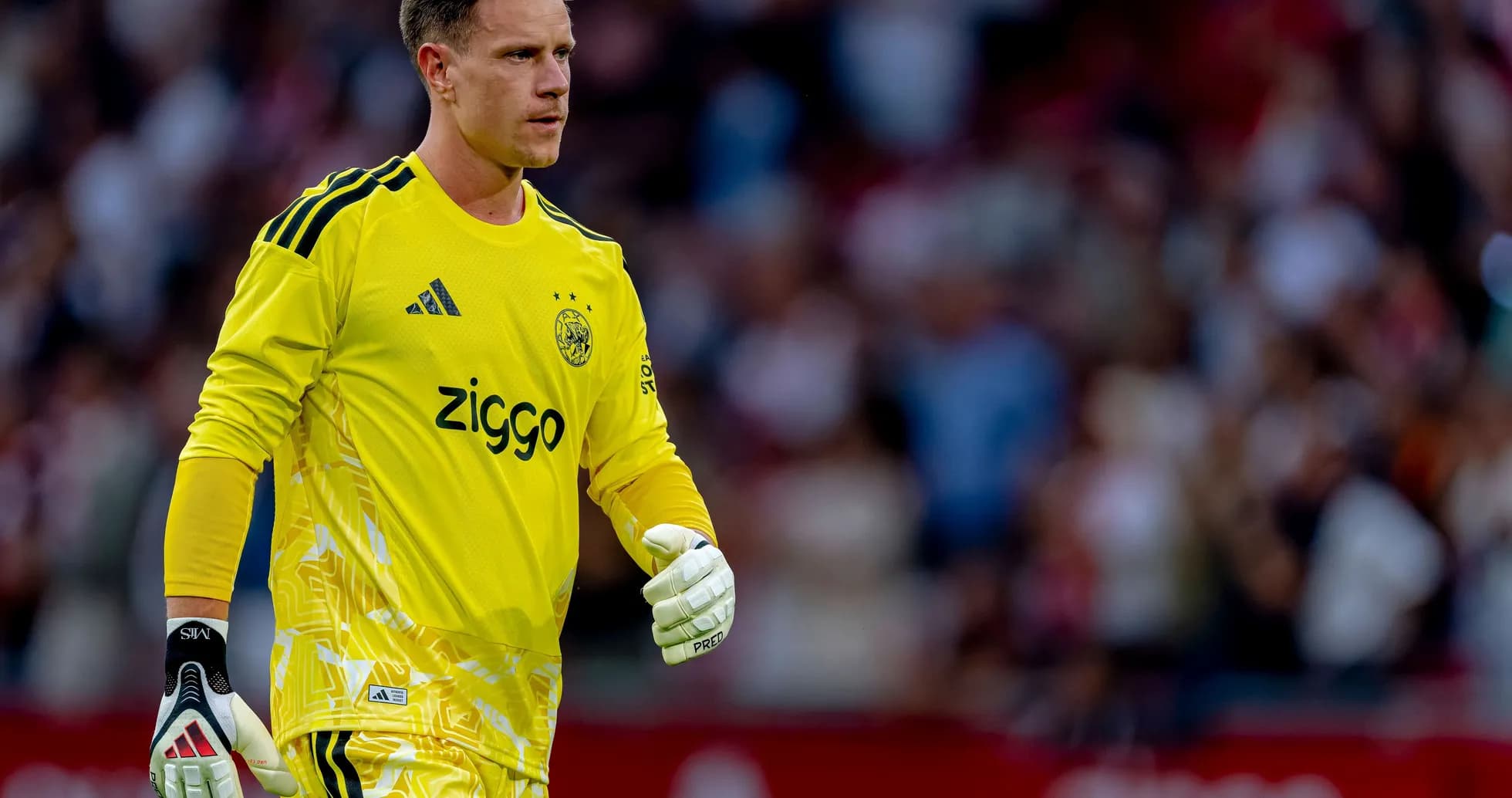 Goalkeeper in yellow kit walking on the pitch