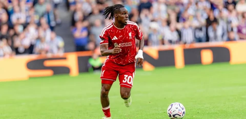 Player in red jersey running with soccer ball