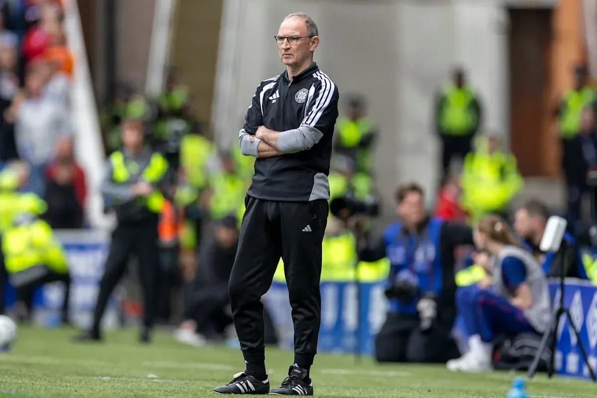 Coach observing match from sidelines with arms crossed