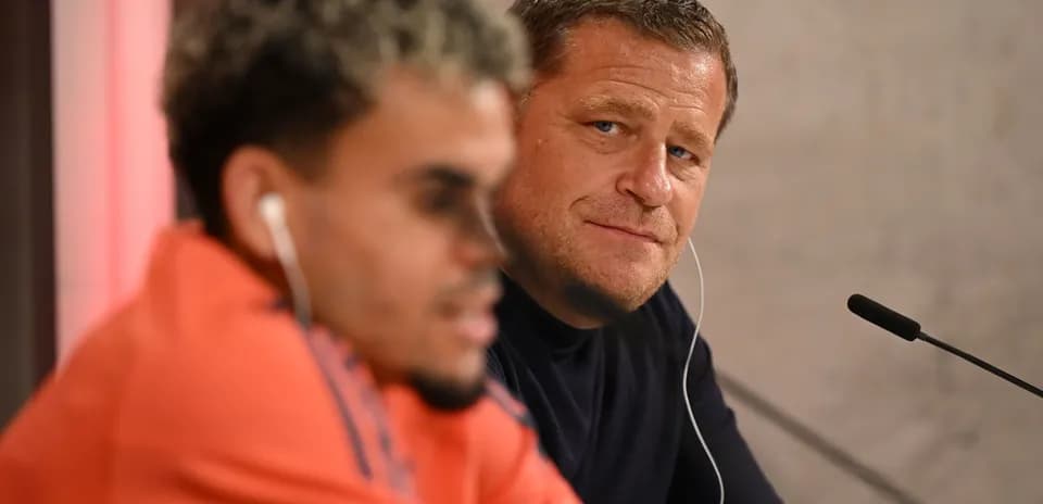 Two individuals at a press conference table