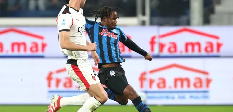 AC Milan player tackling Atalanta forward