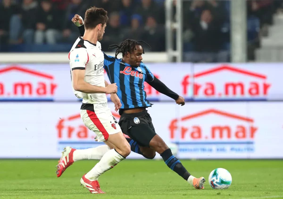 AC Milan player tackling Atalanta forward