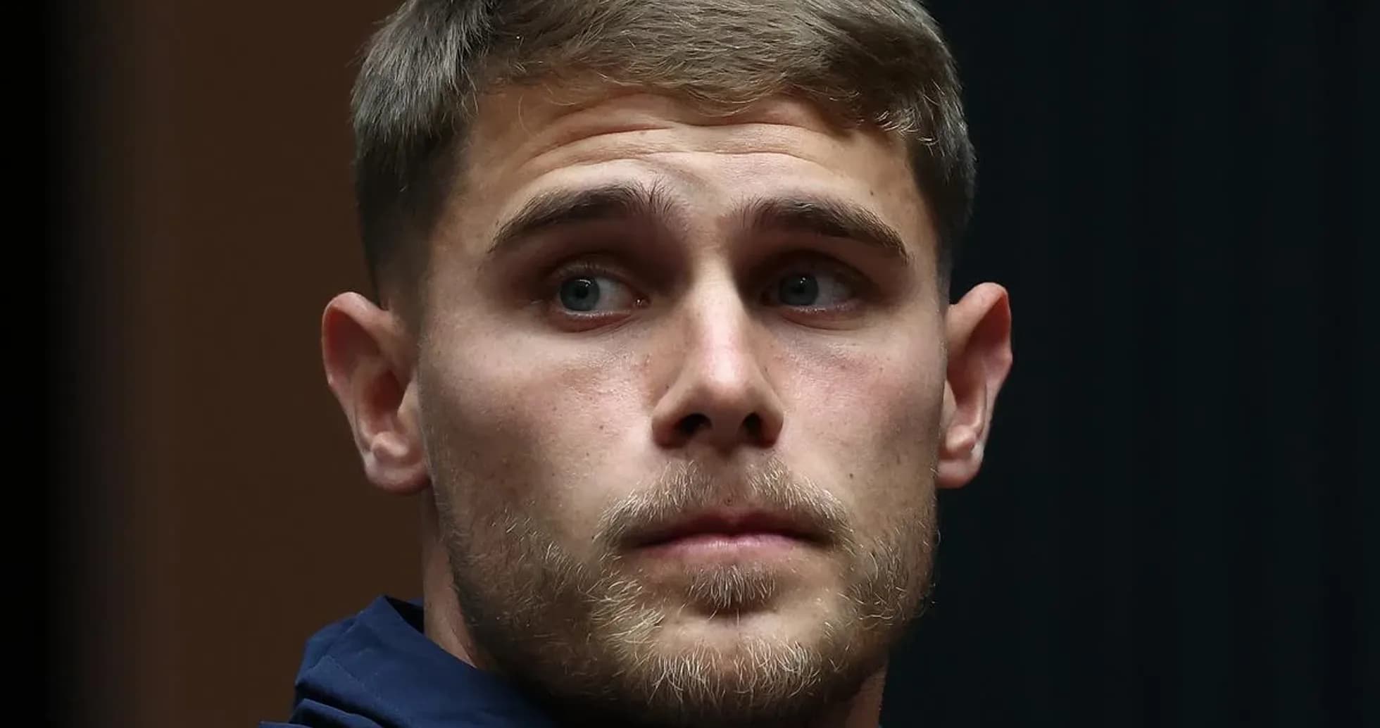 Player in a navy jacket during press event