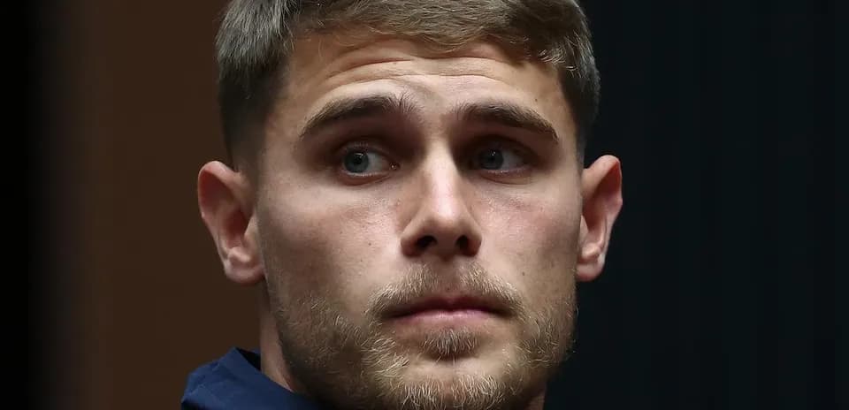 Player in a navy jacket during press event