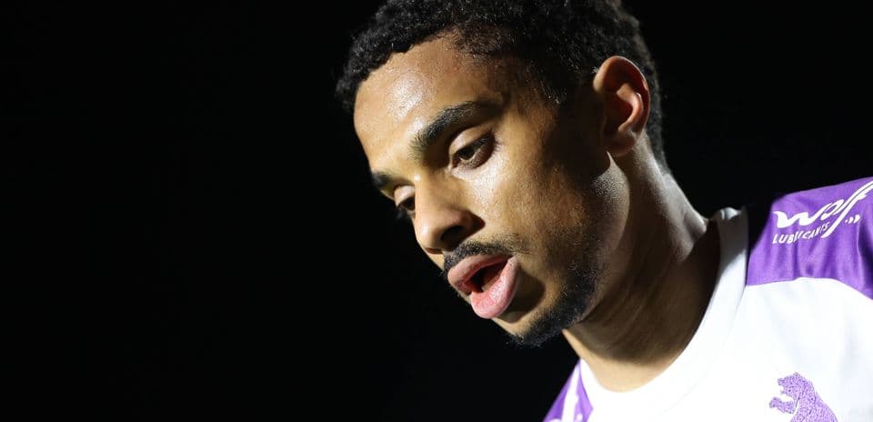 Player in a white and purple jersey during match