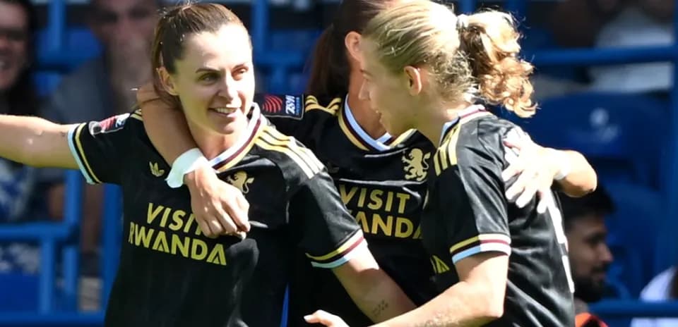 Three players celebrating a goal in black jerseys