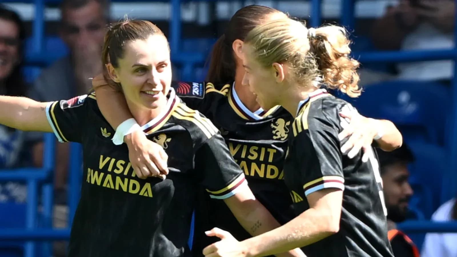 Three players celebrating a goal in black jerseys