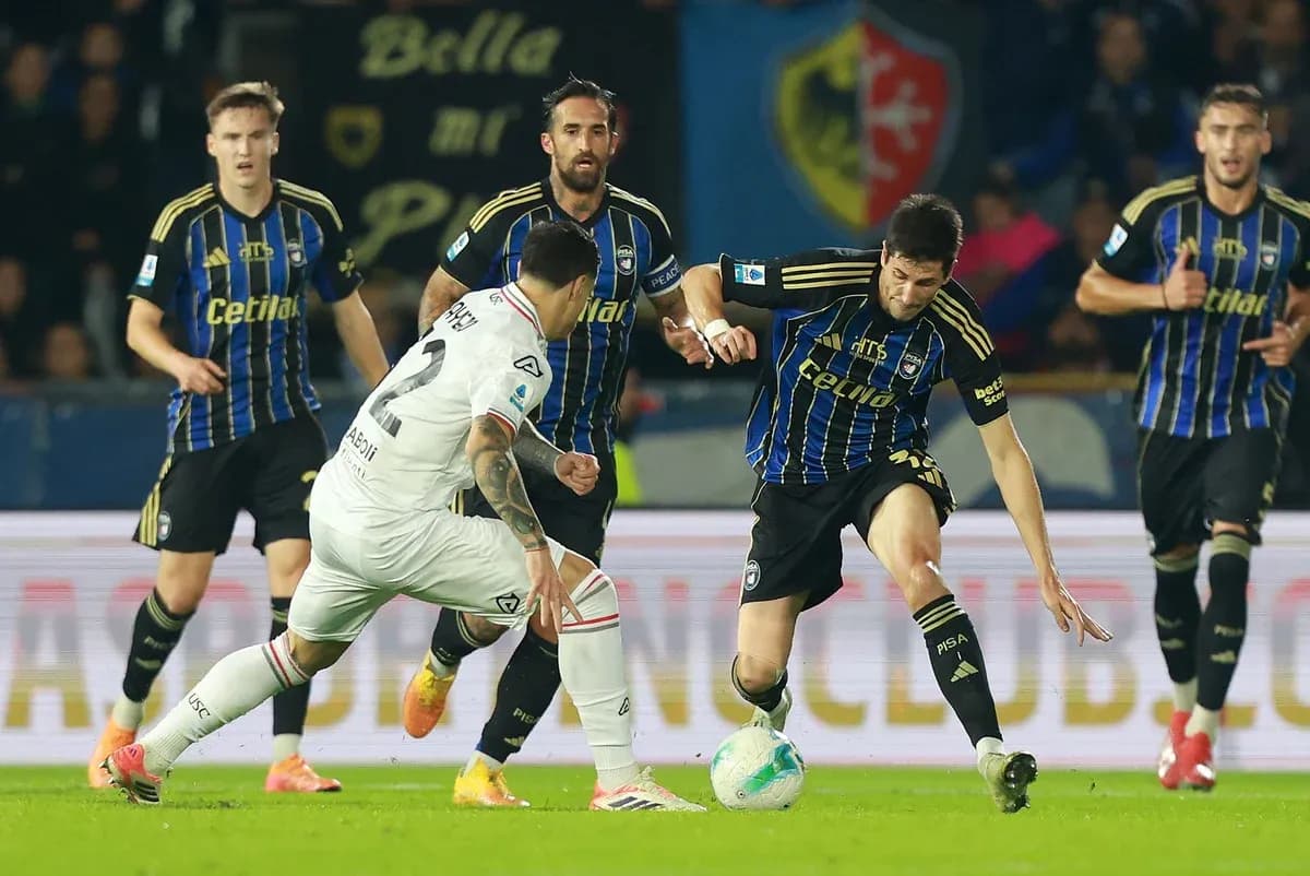 Cremonese player challenging Pisa opponent for ball