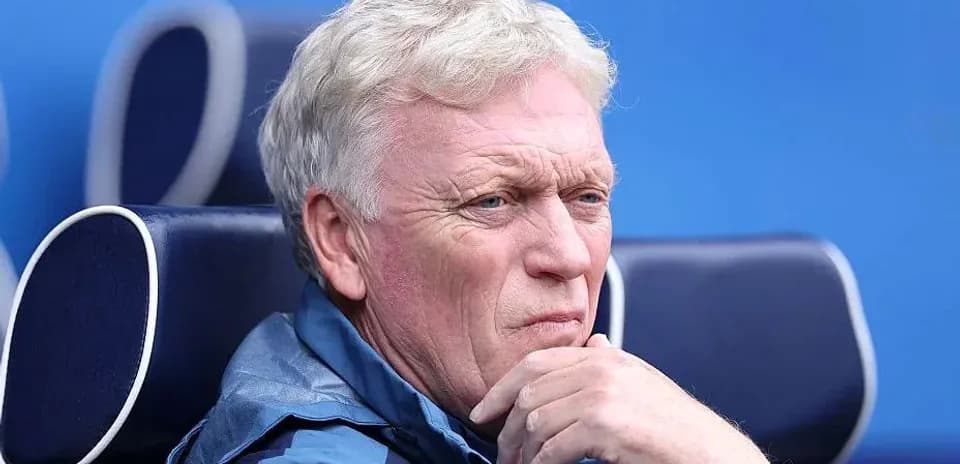 Manager seated on bench during match