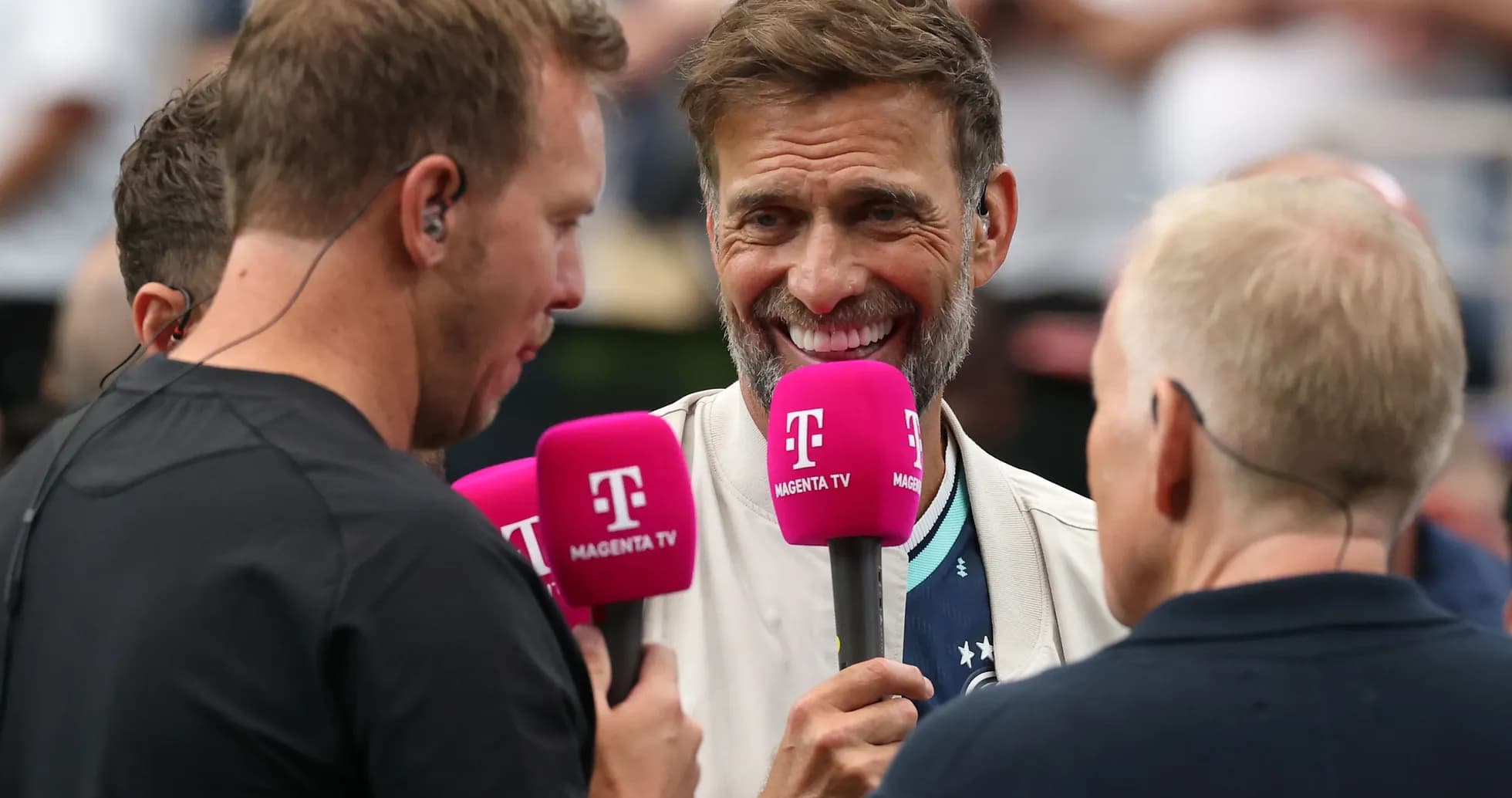 Four broadcasters holding microphones during an interview
