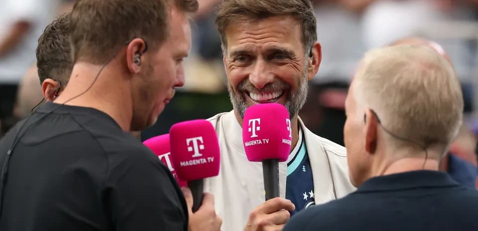 Four broadcasters holding microphones during an interview