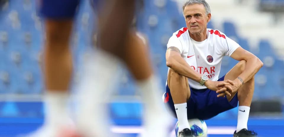Coach squatting during training session on field