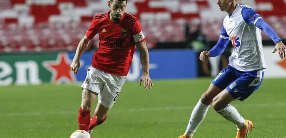 Benfica player dribbling against Lech Poznan