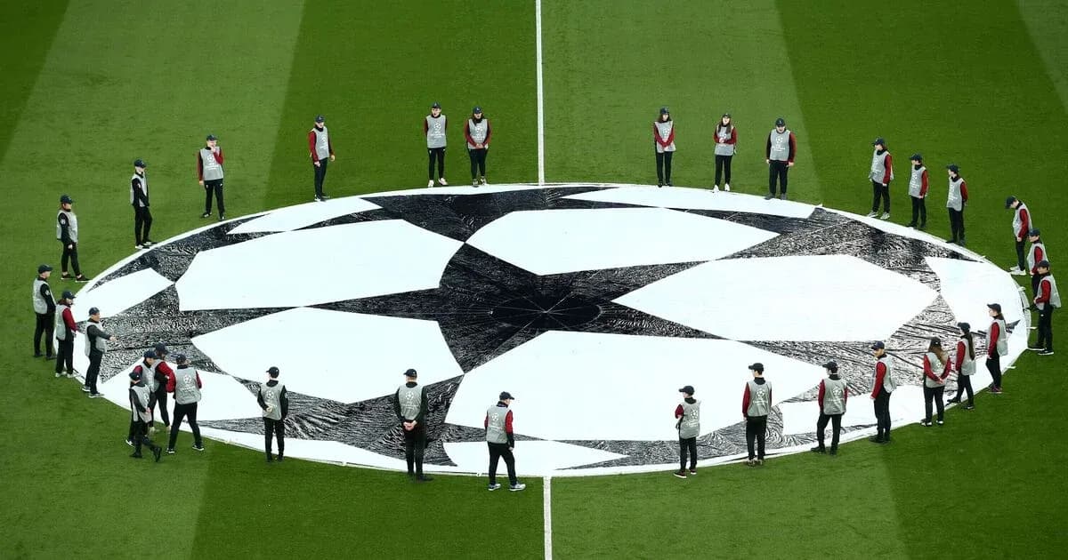 Ground staff preparing UEFA Champions League logo on pitch