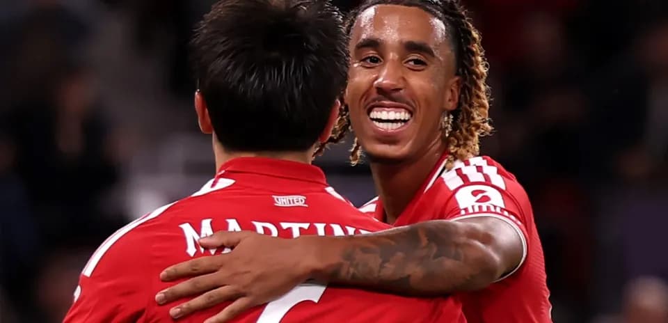 Two players celebrating in red jerseys during match