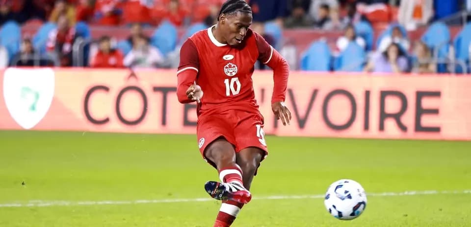 Player in red jersey kicking a soccer ball