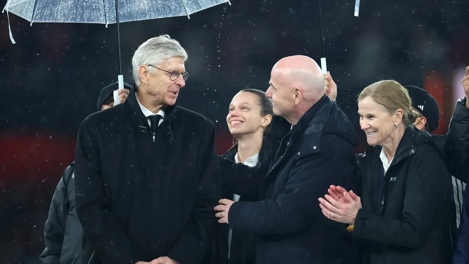 Group of officials under an umbrella during event