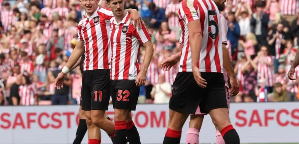 Sunderland players celebrating a goal together on pitch