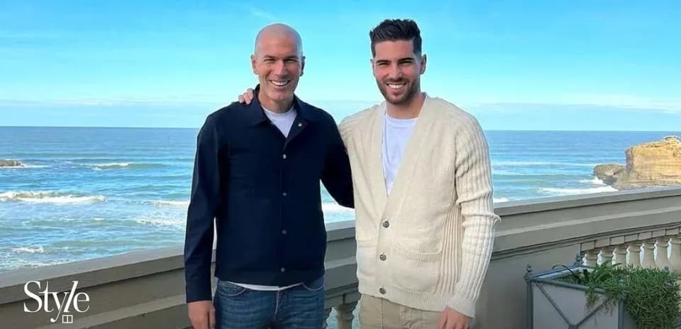 Two men posing together with ocean background