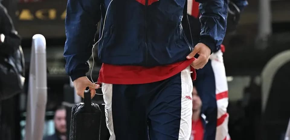 Player in tracksuit arriving at event location