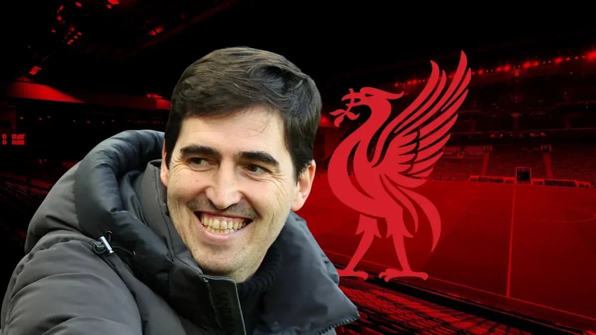 Coach smiling in front of Liverpool stadium backdrop