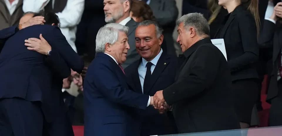 Three individuals shaking hands in a stadium box
