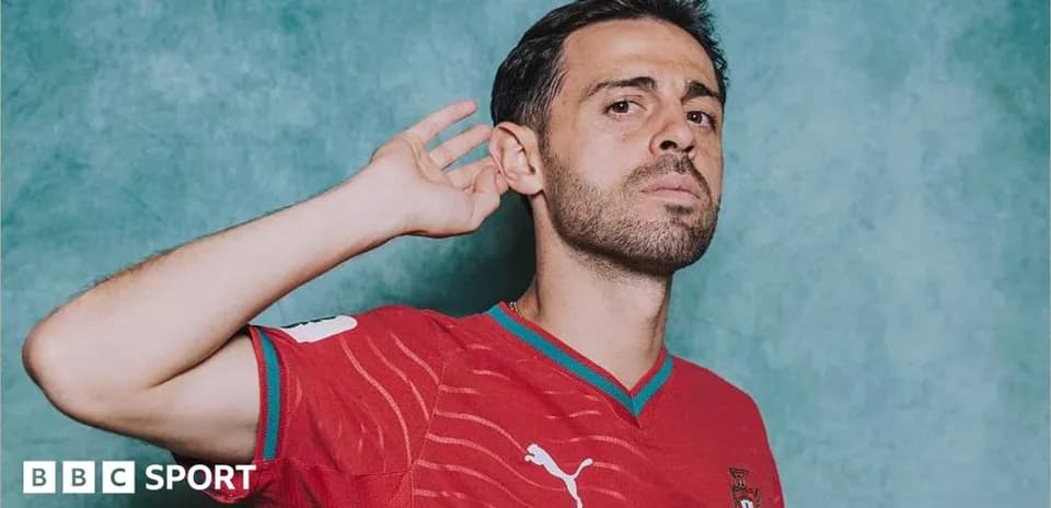 Player in red Portugal jersey posing with hand raised