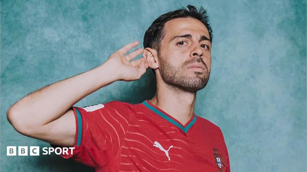Player in red Portugal jersey posing with hand raised