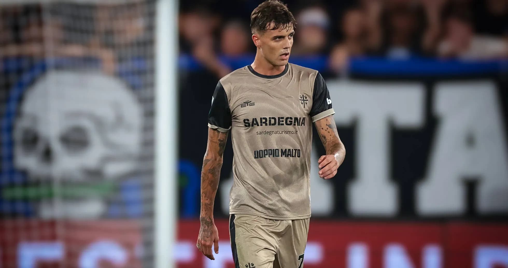 Player in beige jersey walking on the pitch