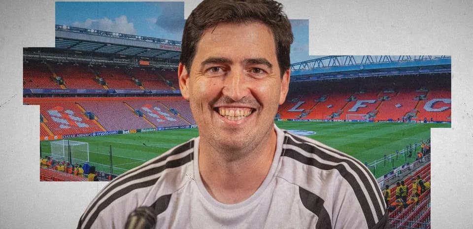Man smiling in Liverpool FC training shirt at stadium