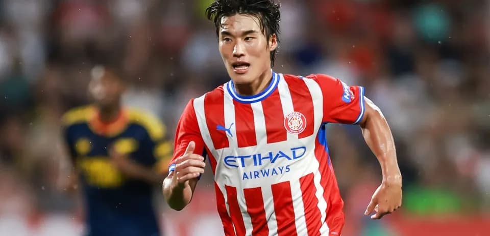 Player running with ball in Girona FC kit