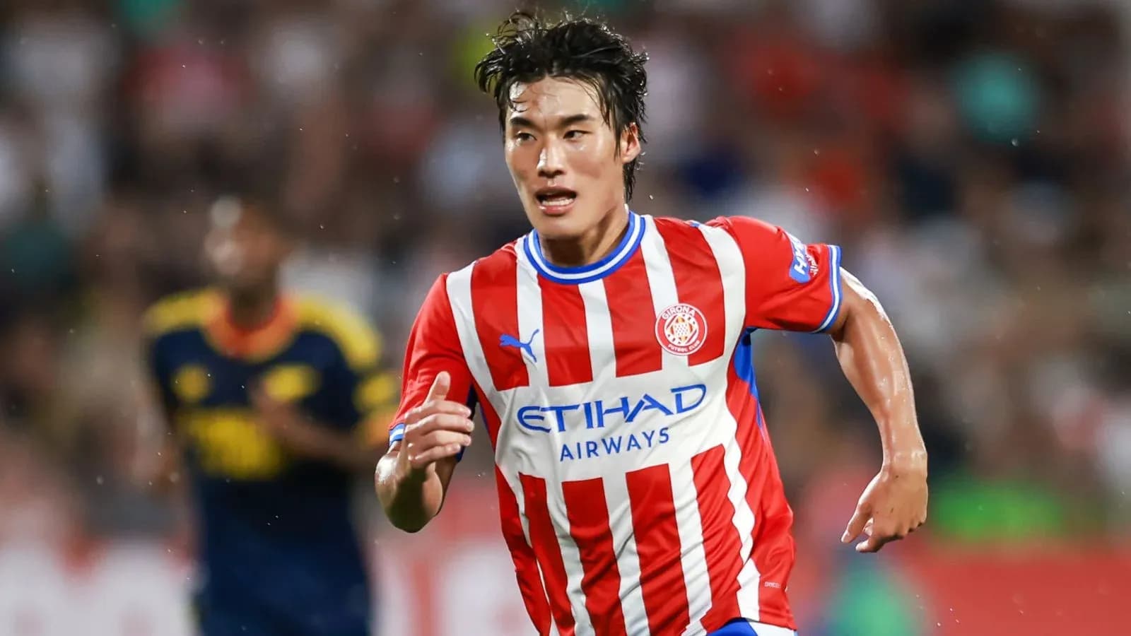 Player running with ball in Girona FC kit