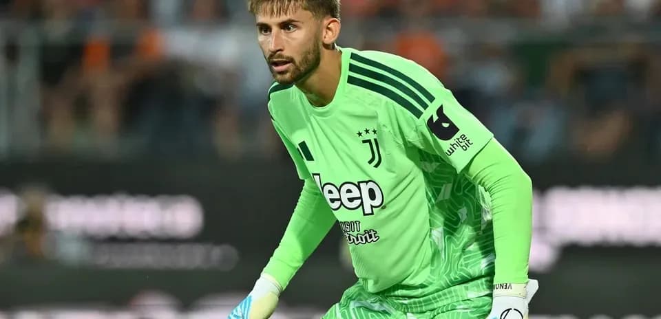 Goalkeeper in green Juventus kit preparing for play