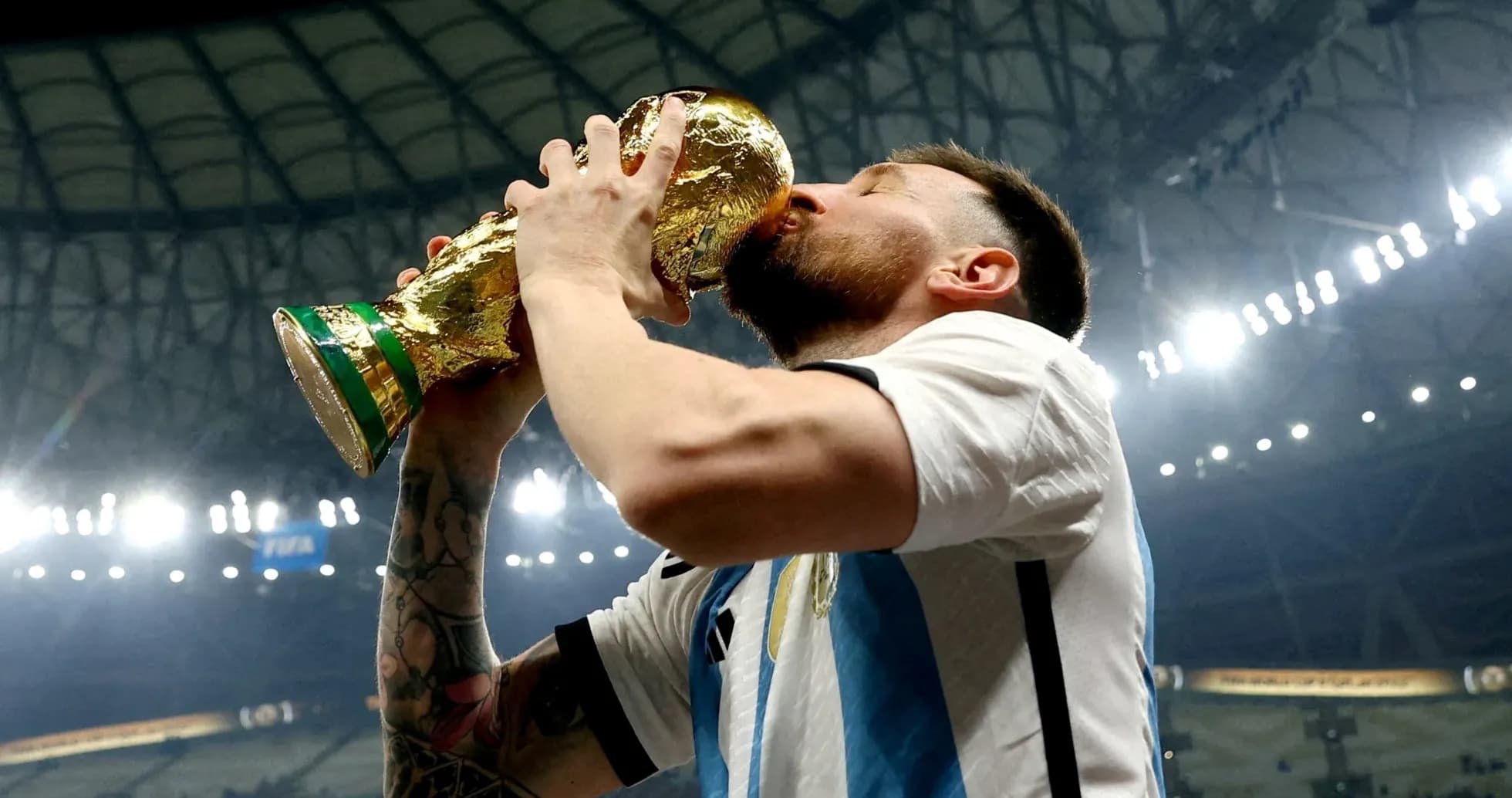 Player celebrating victory by kissing World Cup trophy