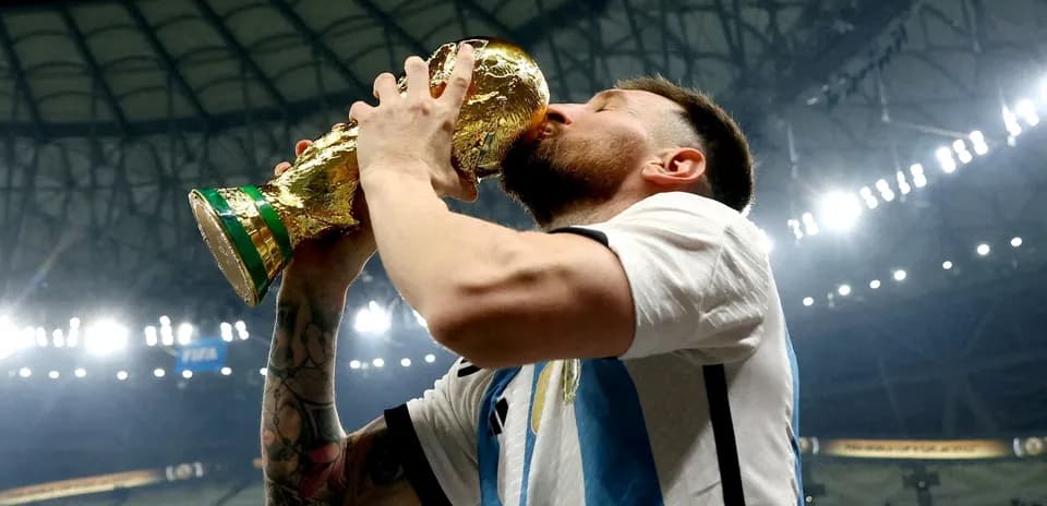 Player celebrating victory by kissing World Cup trophy