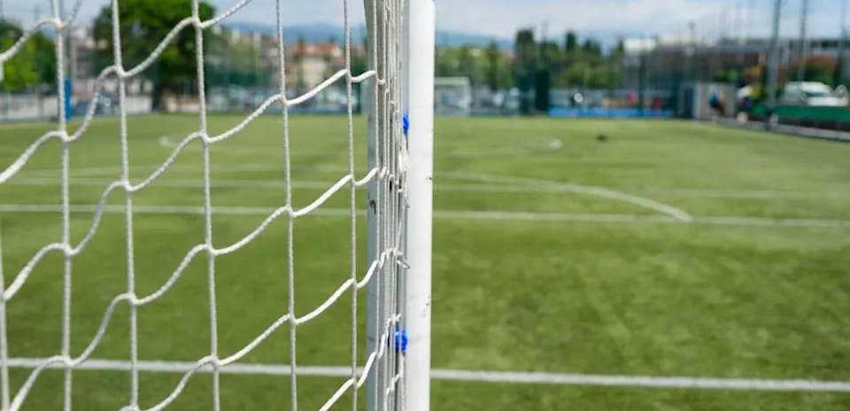 Close-up of soccer goal with field background