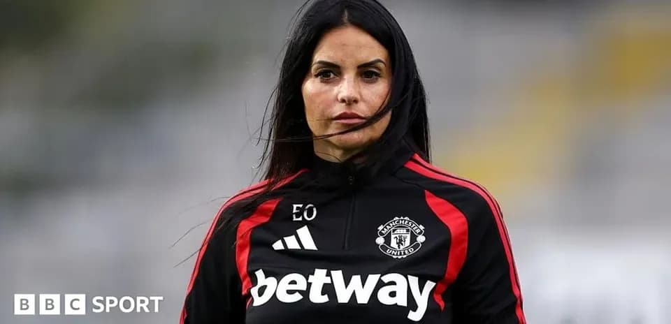 Woman in Manchester United training gear on pitch