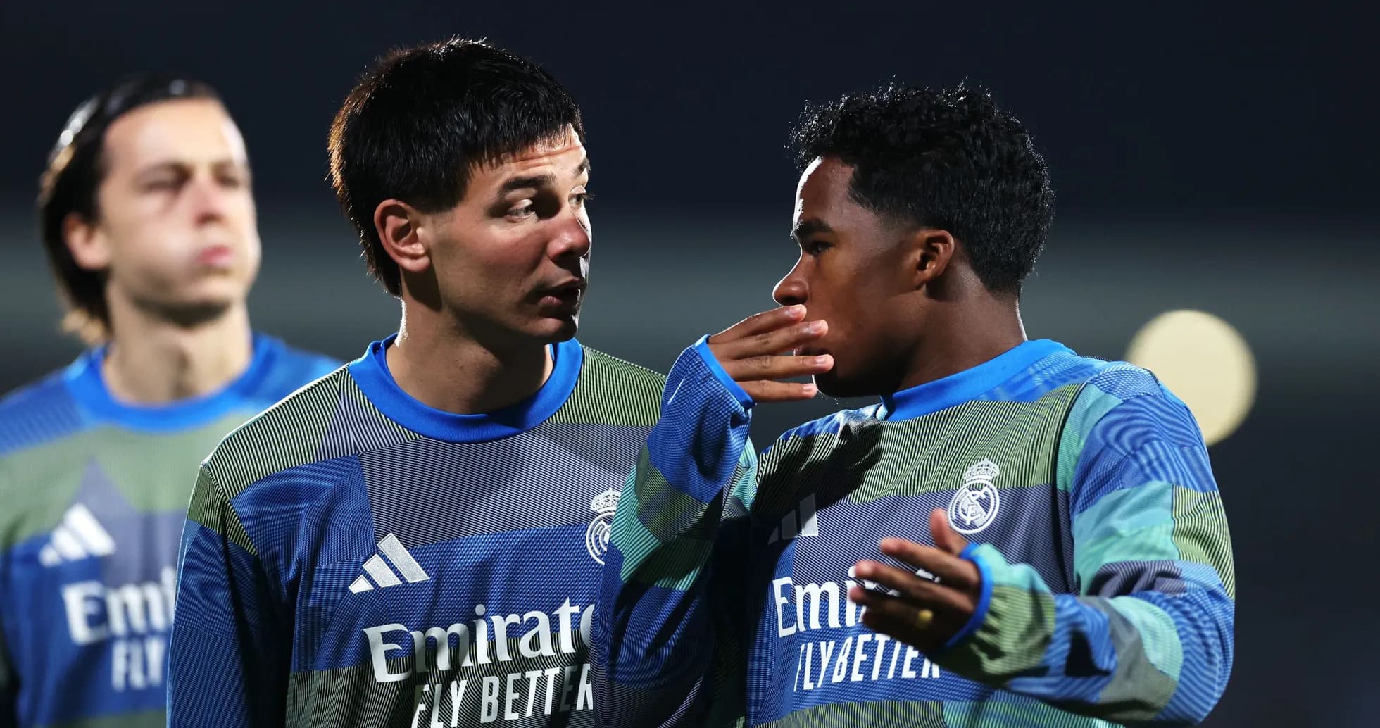 Two players in Real Madrid training discussing strategy