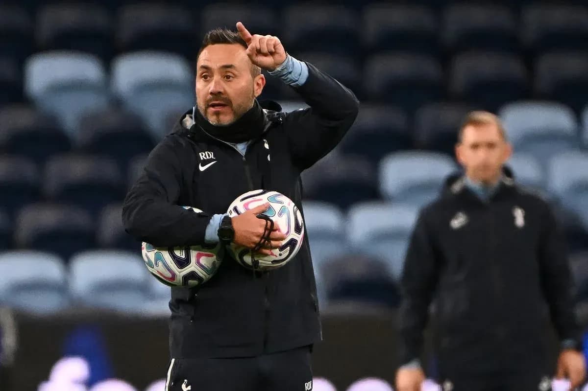 Coach directing players while holding footballs