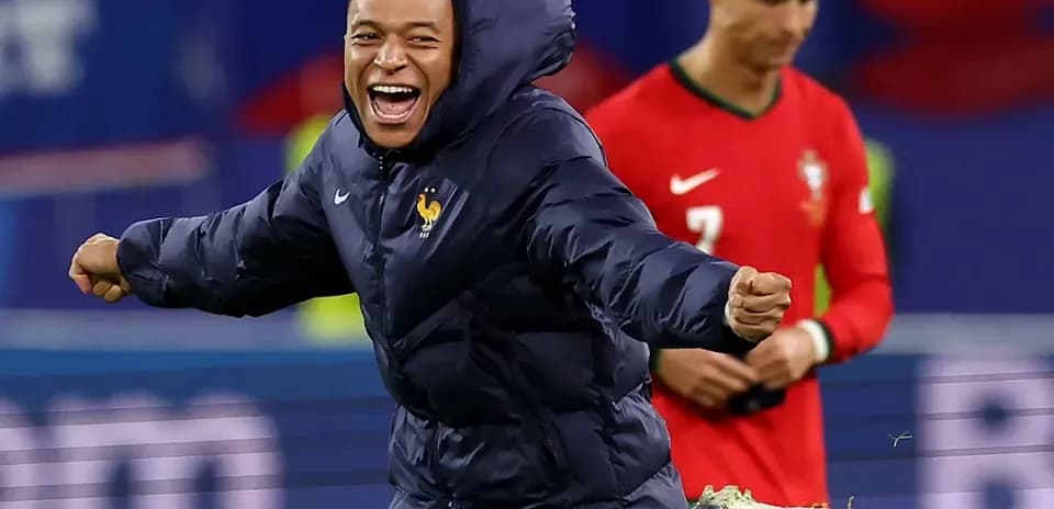 Player celebrating in a winter jacket during match