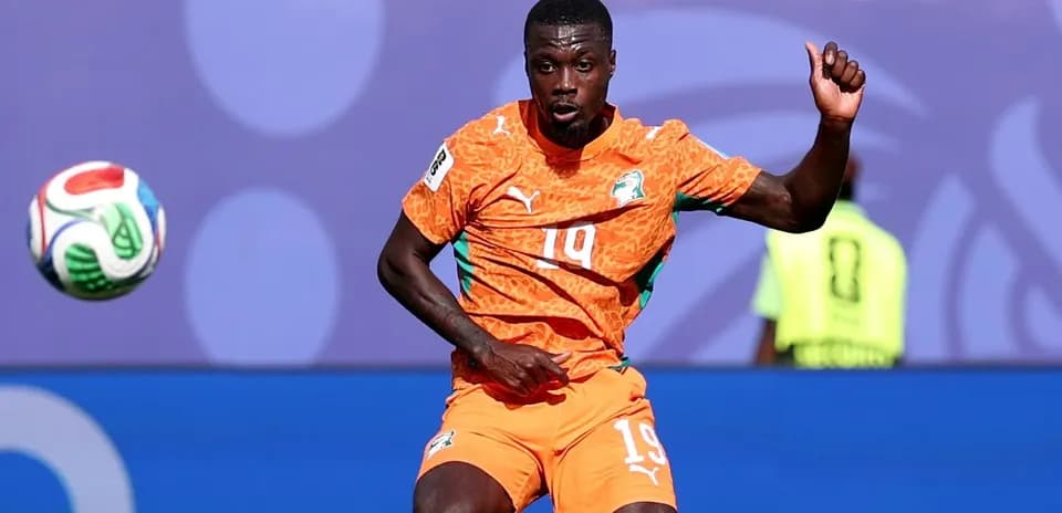 Player in orange kit controlling the ball during match