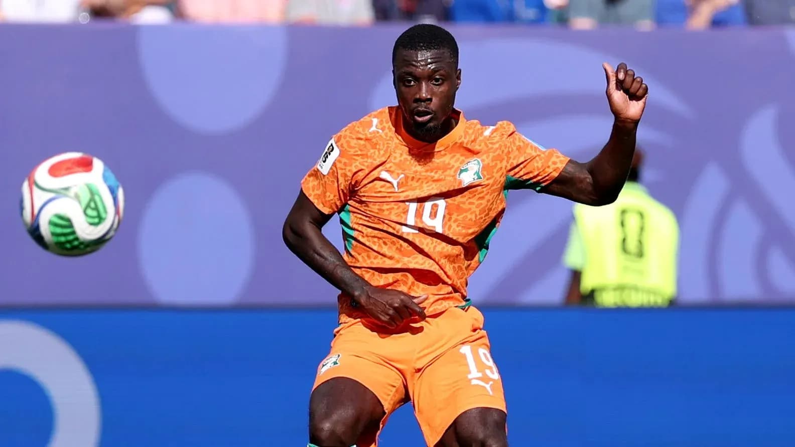Player in orange kit controlling the ball during match