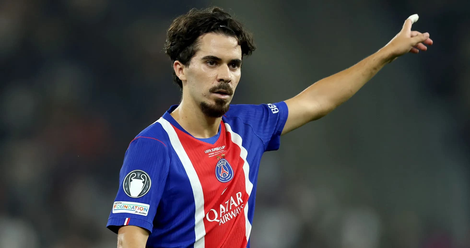 Player gesturing during a football match wearing PSG jersey