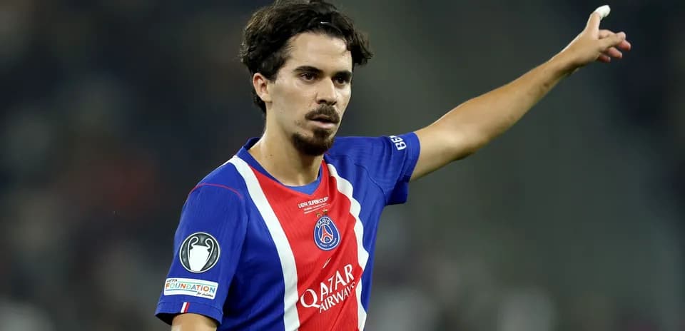 Player gesturing during a football match wearing PSG jersey