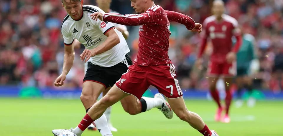 Liverpool player dribbling past Fulham defender
