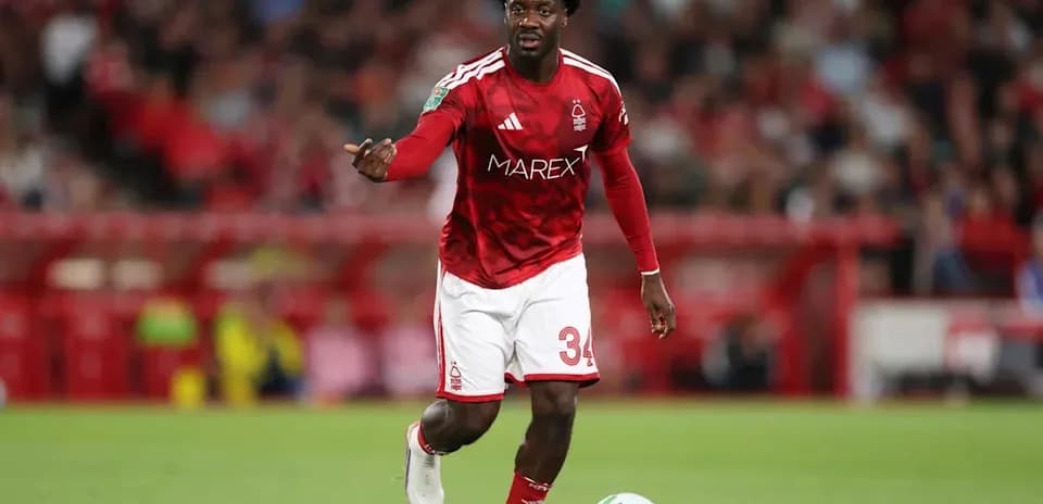 Player in red kit dribbling ball on field