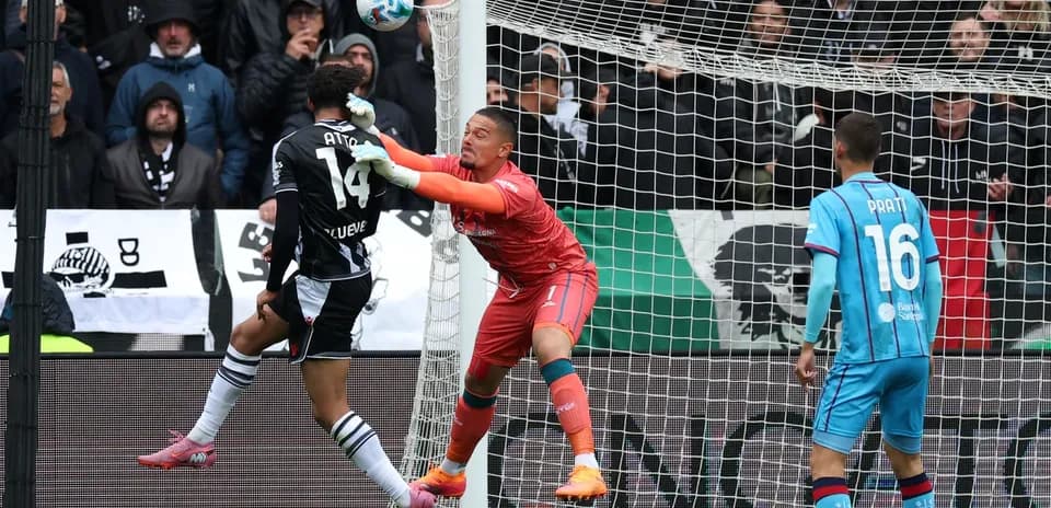 Goalkeeper attempting to save a header in match