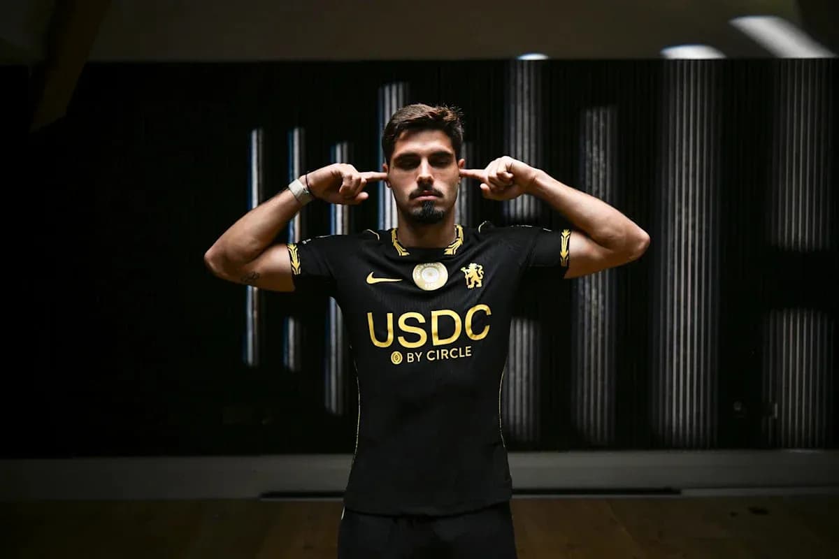 Player in black jersey poses with fingers in ears