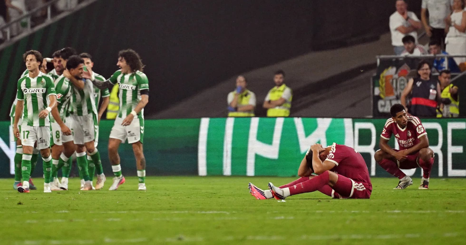 Players reacting after a match, one sitting distressed