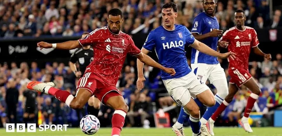Liverpool player shooting while Ipswich defenders approach